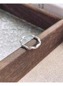 Detailed shot of S925 sterling silver twisted rope ring on a vintage wooden tray