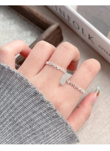 Close-up of dual hollow heart-shaped S925 sterling silver rings worn on a hand