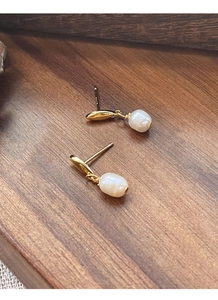 Gros plan détaillé des boucles d'oreilles en argent S925 doré avec perles d'eau douce