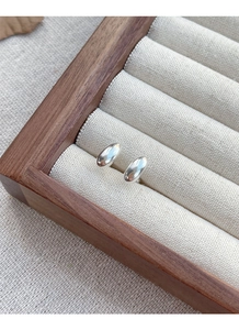 Macro shot of minimalist S925 sterling silver oval bean stud earrings on jewelry display