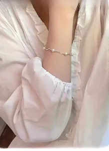Detail of S925 silver wave bracelet with freshwater pearls on a woman wrist