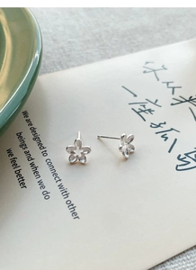 Detail of S925 sterling silver flower stud earrings with minimalist hollow petal design
