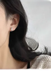 Close-up of minimalist S925 sterling silver oval stud earrings worn on model's ear