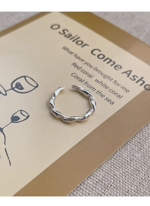 Detailed view of silver twist woven ring on vintage card and rustic linen fabric