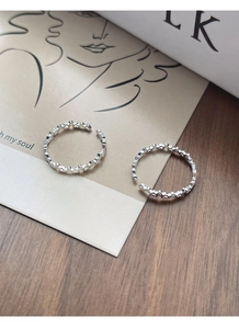 Close-up of minimalist S925 sterling silver hollow heart rings on a wooden table