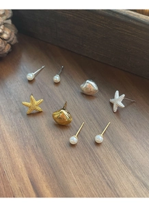 Dettaglio set orecchini a perno in argento S925 con stelle marine, conchiglie e perle