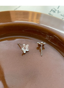 Close-up of S925 sterling silver hollow flower stud earrings with a matte texture finish