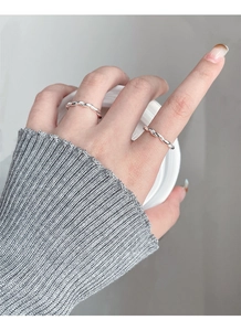Close-up of S925 sterling silver twisted rope rings on hand with cozy knitted sweater