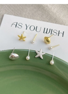 Dettaglio del set di orecchini a perno in argento S925 stella marina e conchiglia