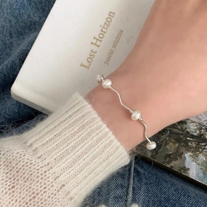 Elegant S925 sterling silver wavy bracelet featuring five white freshwater pearls on a wrist