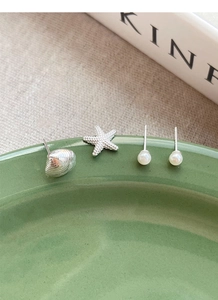 Dettaglio set di orecchini S925 in argento con stelle marine, conchiglie e perle