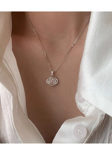 Detail view of S925 sterling silver Ruyi lock necklace with chalcedony on model neck