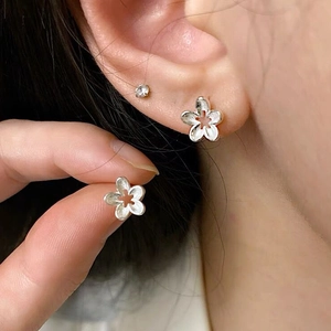 Minimalist S925 sterling silver hollow flower stud earrings with matte finish on ear