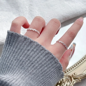 Minimalist S925 sterling silver hollow heart ring set on a hand with cozy knit background