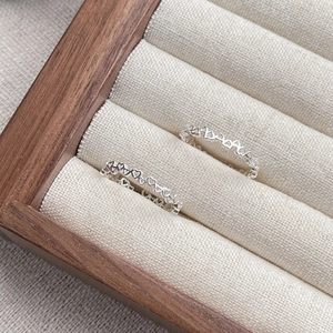 Minimalist S925 sterling silver open rings with hollow heart design on a wooden tray