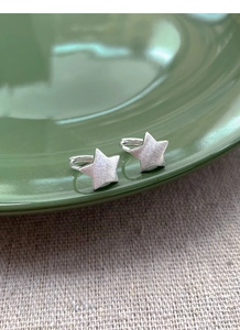 Detail view of S925 sterling silver star earrings featuring a fine brushed metal texture