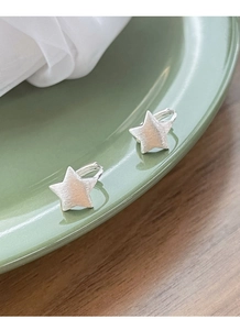 Detail of S925 sterling silver star earrings featuring a brushed matte metal finish
