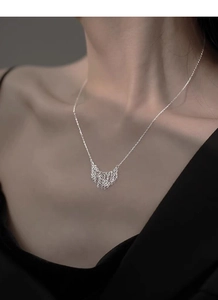 Detail of S925 sterling silver tassel pendant necklace on model's neck for elegant look