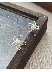 Vista dettagliata di orecchini a fiore in argento S925 con perle bianche eleganti