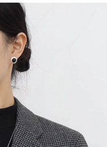 Mannequin portant des boucles d'oreilles en agate noire et blanche au style minimaliste