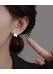 Close-up of a model wearing minimalist S925 silver star stud earrings with a polished finish