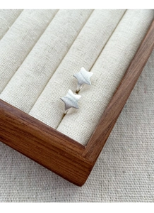 Detailed macro view of S925 sterling silver star earrings with a brushed matte finish surface