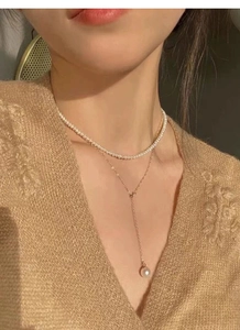 Détail du collier en Y étagé en argent S925 avec perles blanches et chaîne dorée