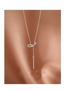 Détail du collier nœud en argent S925 avec cristaux sur fond de soie chaleureux