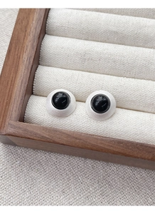 Détail de boucles d'oreilles en argent S925 avec agate noire et motifs concentriques