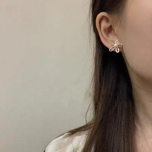 Orecchini a lobo a fiore traforato in argento S925 con perla indossati da una modella