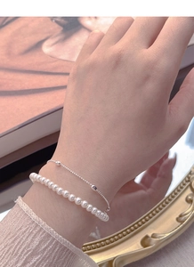 Detail of S925 sterling silver double-layered bracelet with elegant imitation pearls