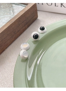 Détail de puces d'oreilles minimalistes en argent S925 avec agate noire et blanche sur plateau