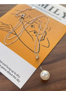 Gros plan du collier Y en argent sterling S925 avec une seule perle ronde blanche