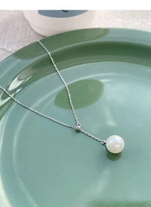 Détail d'un collier Y en argent sterling S925 avec une perle blanche brillante et minimaliste