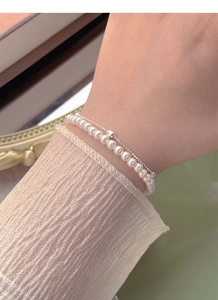 Close-up of double-layer S925 silver bracelet with white pearls on a female wrist