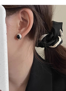 Détail du clou d'oreille en argent S925 avec agate noire et texture en spirale portée