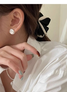 Détail de boucles d'oreilles S925 et d'un collier de perles sur un modèle