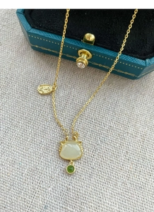 Détail du collier chat en argent S925 avec pierres blanches et vertes sur boîte à bijoux