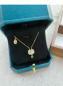 Détail d'un collier en argent s925 doré avec pendentif chat en jade dans son écrin