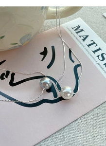 Detailed close-up of S925 silver snake chain with elegant white and grey pearl pendants