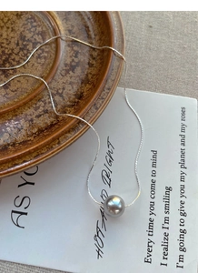 Macro shot of 9-10mm grey round pearl pendant on elegant S925 silver snake chain
