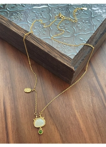 Détail du collier en argent S925 doré avec pendentif en jade et médaillon porte-bonheur