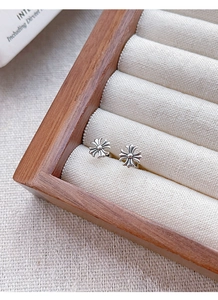 Close-up of S925 sterling silver cross earrings with vintage oxidized finish in a jewelry box
