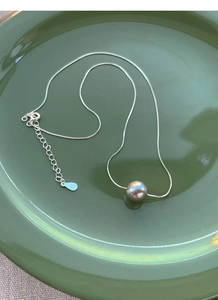 Detail of S925 sterling silver snake chain showing the hallmark and grey pearl pendant