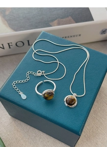 Detailed view of S925 silver tiger eye necklace and adjustable ring set on jewelry box