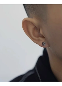 Close-up of vintage S925 silver cross earring with retro blackened texture on ear