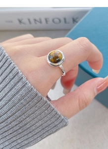Macro shot of silver S925 ring featuring a round tiger eye stone with silk luster