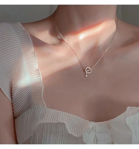 Detailed close-up of a sterling silver planet necklace on a model with soft lighting