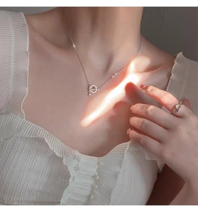 Detail of S925 silver planet necklace and geometric ring with natural light effects