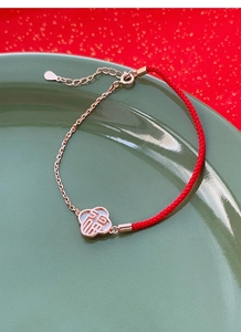 Détail du bracelet en argent S925 avec cordon rouge, trèfle nacré et caractère chinois Fu